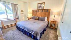Red Lodge condo for rent - A bedroom with a large bed and a window with a view of trees.