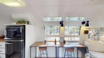 Cat Spring apartment for rent - A kitchen with a black fridge and a table with four stools.