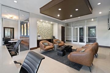 Dallas apartment for rent - A modern living room with a black leather chair and brown leather chairs.