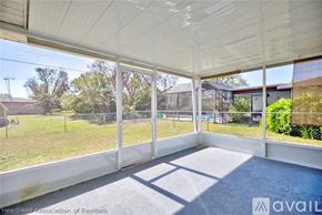Sebring house for rent - A sunny day in a spacious room with a view of a fenced yard and trees.