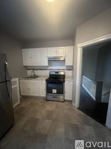 Philadelphia house for rent - A kitchen with white cabinets and a stainless steel refrigerator.