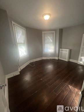 Philadelphia house for rent - A room with wooden floors and two windows.