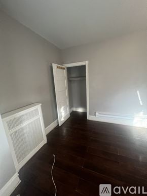 Philadelphia house for rent - A room with a white radiator and wooden flooring.