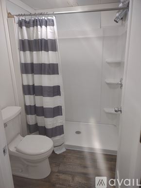 Clearwater apartment for rent - A bathroom with a toilet, a shower curtain, and a towel rack.