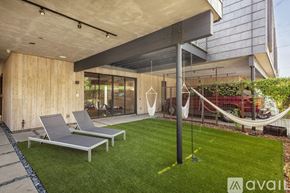 Dallas house for rent - A modern outdoor lounge area with two lounge chairs and a hammock.