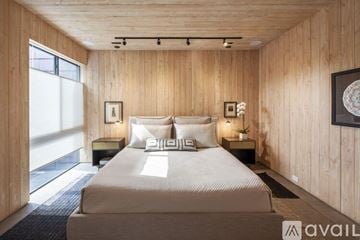 Dallas house for rent - A bedroom with a large bed and wooden walls.