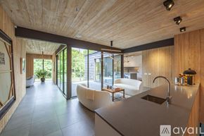 Dallas house for rent - A modern kitchen with wooden ceiling and a large island.