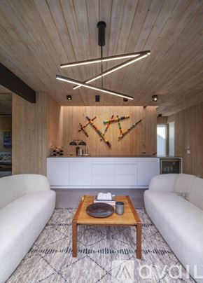 Dallas house for rent - A modern living room with a wooden ceiling and a white sofa.
