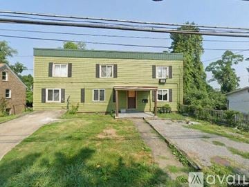 Morgantown apartment for rent - A green two-story house with a front yard and a driveway.