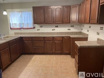 Dayton house for rent - A kitchen with brown cabinets and a granite countertop.