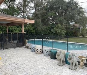 Palm Beach Gardens house for rent - A pool surrounded by statues and a fence.