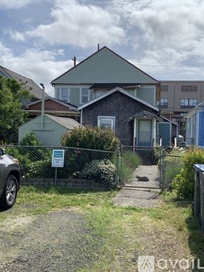 Aberdeen apartment for rent - A house with a green roof is surrounded by a fence and has a sign in front of it.