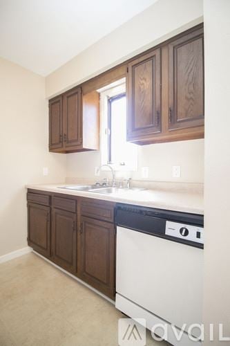 Toledo apartment for rent - A kitchen with brown cabinets and a white dishwasher.