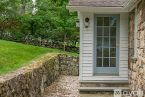 Norwalk house for rent - A house with a grey door and a stone wall.