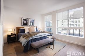 Denver apartment for rent - A bedroom with a large bed and a window overlooking a cityscape.