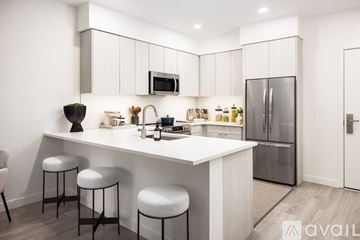 Denver apartment for rent - A modern kitchen with white cabinets and a central island.