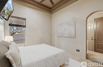 Mesa house for rent - A bedroom with a large bed and a painting on the wall.