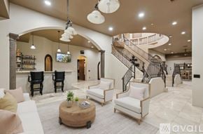Mesa house for rent - A living room with a spiral staircase and a coffee table.