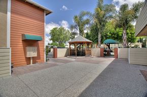 Sunnyvale apartment for rent - A building with a green awning and a gazebo in the middle of a paved area.