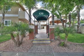 Sunnyvale apartment for rent - The entrance to apartment 430 is surrounded by trees and shrubbery.