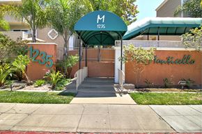 Redwood City apartment for rent - The entrance to a building with a green awning and a sign