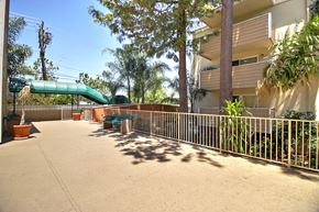 Redwood City apartment for rent - A green slide is in the middle of a concrete courtyard.