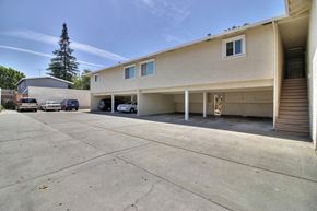 Sunnyvale apartment for rent - A large parking lot in front of a two-story building with a garage.