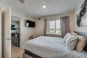 Richardson house for rent - A bedroom with a large bed and a flat screen TV mounted on the wall.