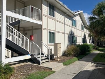 Clearwater apartment for rent - A white building with a red fire alarm box on the staircase.
