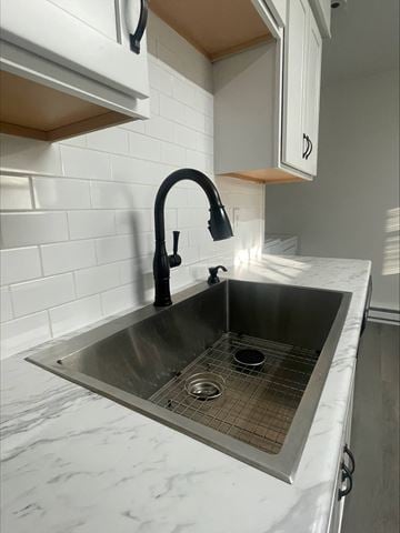 Lima apartment for rent - A kitchen sink with a black faucet and a white countertop.