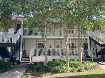 Clearwater apartment for rent - A white building with a balcony and trees in front.