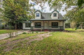 Jacksonville house for rent - A green house with a porch and a small front yard.