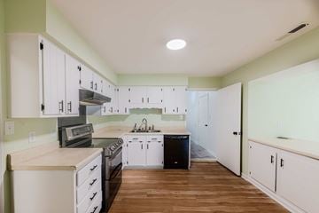 Jacksonville house for rent - A kitchen with white cabinets and a wooden floor.