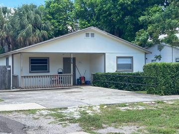 Clearwater house for rent - A white house with a porch and a hedge in front.