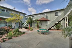 Sunnyvale apartment for rent - a patio with a table and chairs in front of a building