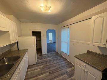 Fremont apartment for rent - A kitchen with white cabinets and a wooden floor.