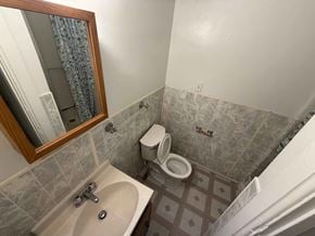 Fremont apartment for rent - A bathroom with a toilet, sink, and mirror.
