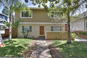 Palo Alto apartment for rent - the front of a yellow house with a sidewalk and grass