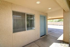 Tucson townhouse for rent - A blue door is on the right side of a tan building.