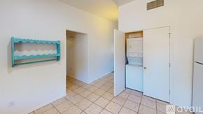 Tucson townhouse for rent - A room with a white door, a white fridge, and a white wall with a blue shelf.