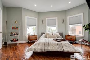 Boston apartment for rent - A bedroom with a large bed, a chair, and a window.