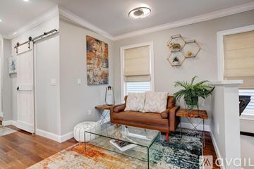 Boston apartment for rent - A living room with a couch, a rug, and a painting on the wall.