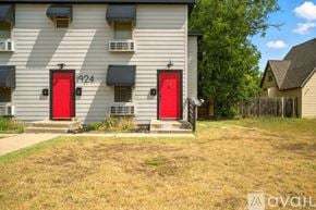Lubbock townhouse for rent - A building with the number 1924 on it has two red doors.