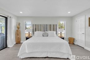 Palm Coast house for rent - A bedroom with a large bed and a window with blinds.
