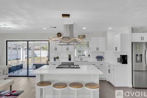 Palm Coast house for rent - A modern kitchen with white cabinets and a large island.