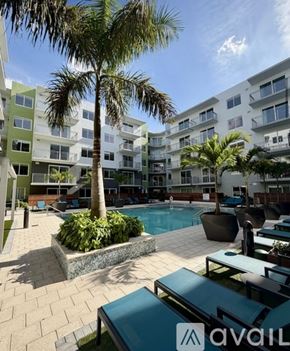 Tampa apartment for rent - A pool surrounded by palm trees and lounge chairs.