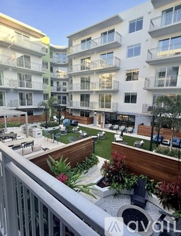 Tampa apartment for rent - A kitchen with white cabinets and a black stove top oven.