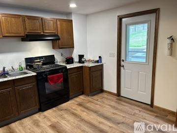 Bellefonte apartment for rent - A kitchen with wooden cabinets and a black stove top oven.