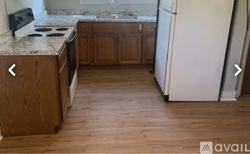Knoxville house for rent - A kitchen with wooden cabinets and a white fridge.