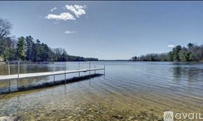 Ellsworth house for rent - A dock extends into a lake with trees in the background.